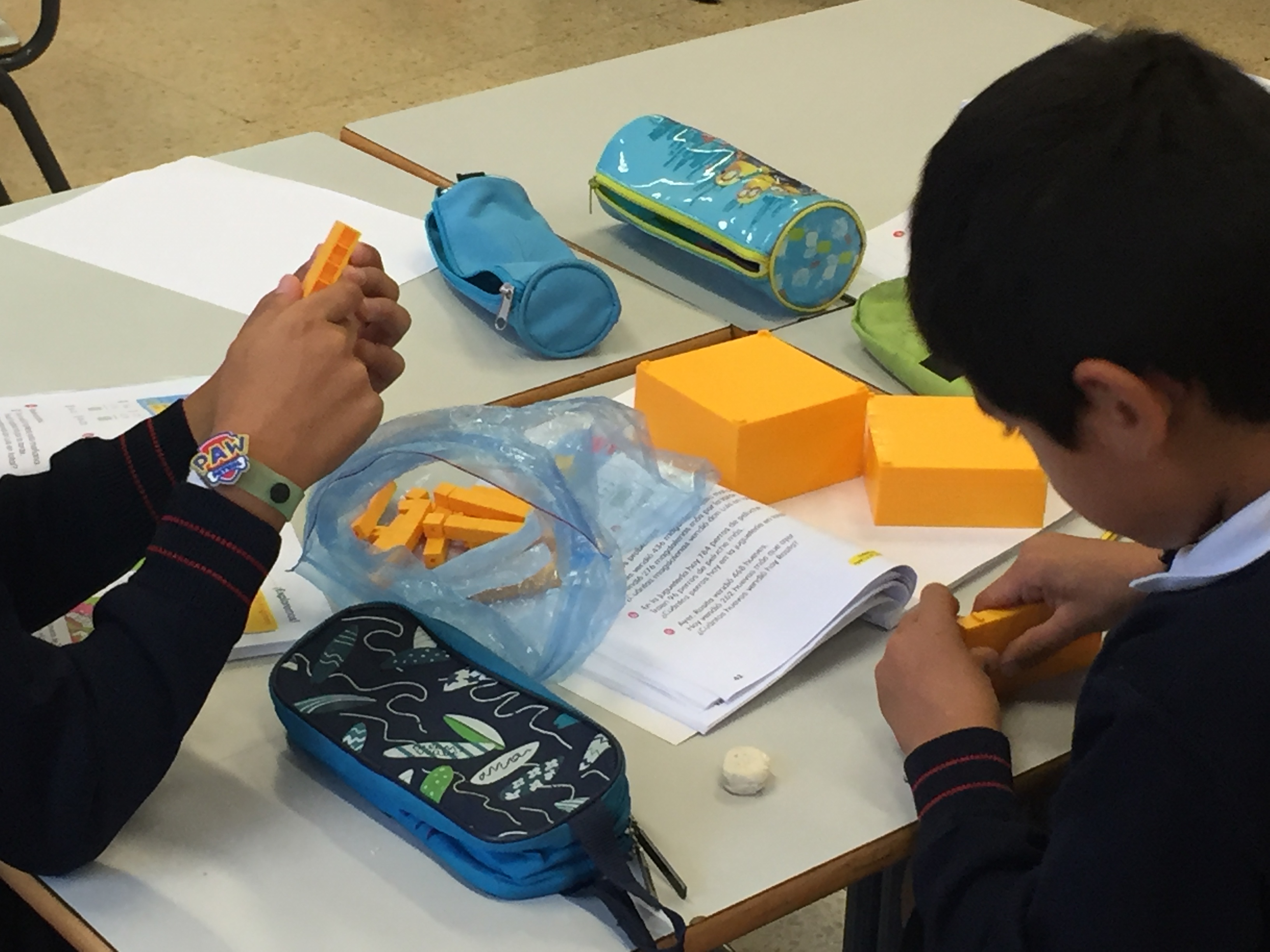 Dos niños trabajan con los manipulativos de Matemáticas Singapur.