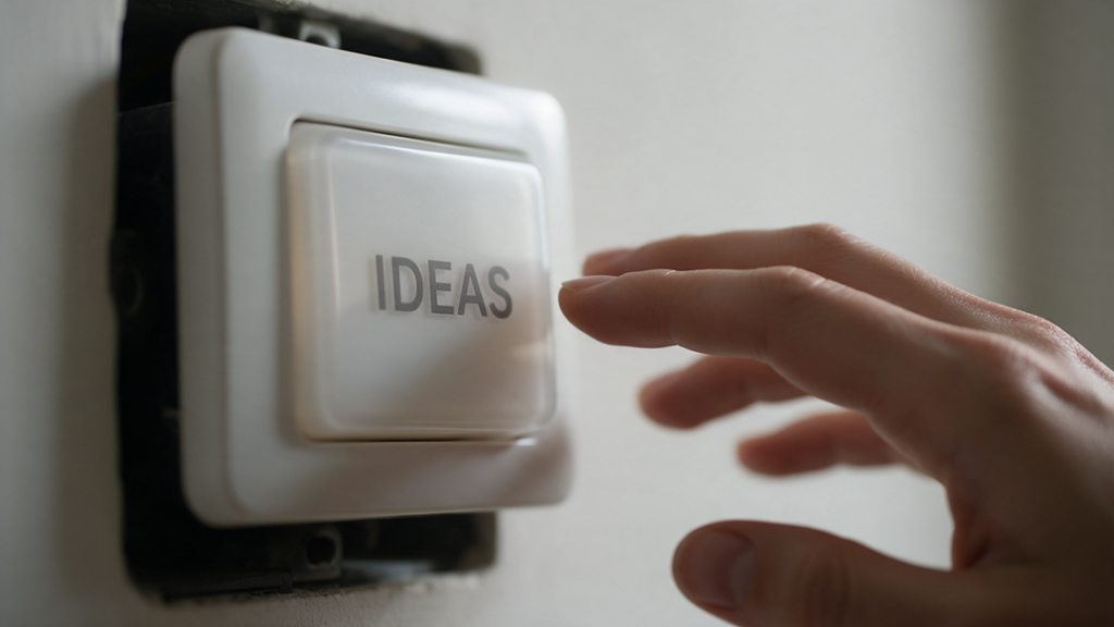 Mano dándole a un interruptor en el que pone "ideas"